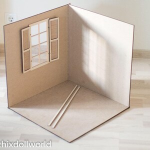 May include: A miniature room with a wooden window and two wooden dowels on the floor. The walls are painted a light brown color.