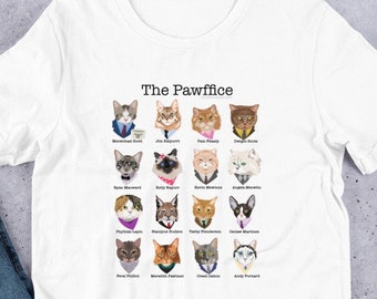 May include: White t-shirt with a graphic of cat faces in a grid. The text "The Pawffice" is at the top of the graphic. Each cat face has a name underneath it, such as "Michael Scott" and "Dwight Schrute".
