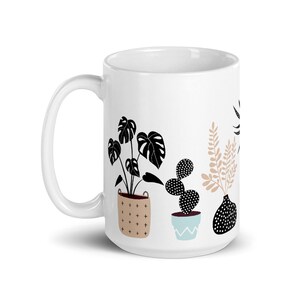 May include: White ceramic mug with a black and white illustration of potted plants. The plants include a cactus, a monstera, and a leafy plant. The pots are decorated with geometric patterns.