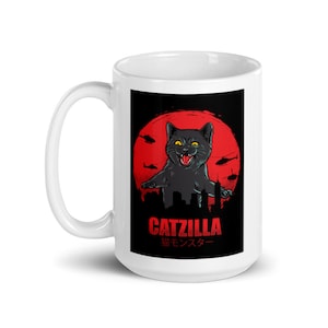 May include: White ceramic mug with a black cat monster illustration. The cat is standing on a city skyline with a red sun and helicopters in the background. The text "CATZILLA" and "猫モンスター" is printed on the mug.