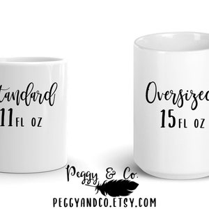 May include: Two white ceramic mugs with black text. The mug on the left says "Standard 11 fl oz" and the mug on the right says "Oversized 15 fl oz".