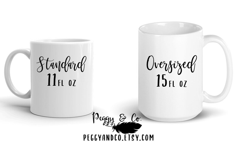 May include: Two white ceramic mugs with black text. The mug on the left says "Standard 11 fl oz" and the mug on the right says "Oversized 15 fl oz".