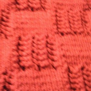May include: A close-up of a red textured fabric with a blurred pattern of repeating shapes.