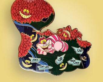 May include: A metal enamel pin featuring a pink and white striped cat resting in a dark green forest with red foliage. The pin includes several floating signposts with the text BACK, THAT WAY, UP, and THIS WAY, along with multiple yellow cat smiles.