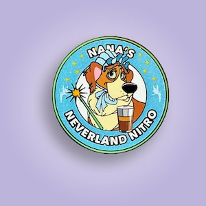 May include: A circular pin featuring a cartoon dog wearing a blue bonnet and holding a wand. The pin has the text "NANA'S NEVERLAND NITRO" in a circular design with a light blue background and gold stars.