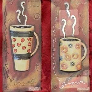 May include: Two decorative wall plaques with a brown background and a stylized illustration of a coffee mug with steam rising from it. The text "Grazie" and "Jana" are written on the plaques.