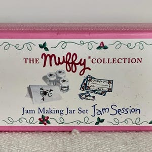 May include: Pink box for "The Muffy Collection" Jam Making Jar Set. The box features a decorative border with green leaves and red flowers. The front of the box shows images of jam jars, labels, and a small card.