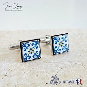May include: Pair of silver cufflinks with blue and yellow patterned tile designs. The cufflinks are hand-made in France.