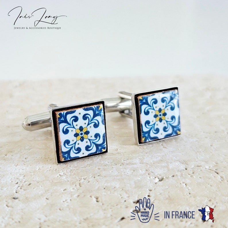 May include: Pair of silver cufflinks with blue and yellow patterned tile designs. The cufflinks are hand-made in France.