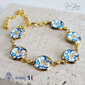 Può includere: Braccialetto in oro con sei piastrelle rotonde in ceramica blu e bianca con un motivo floreale. Il braccialetto è realizzato in Francia ed è fatto a mano.