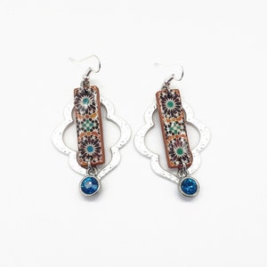 Peut inclure: Une paire de boucles d'oreilles argent&eacute;es avec un pendentif en forme de goutte de pierre bleue. Les boucles d'oreilles pr&eacute;sentent un pendentif rectangulaire avec un motif g&eacute;om&eacute;trique color&eacute;.