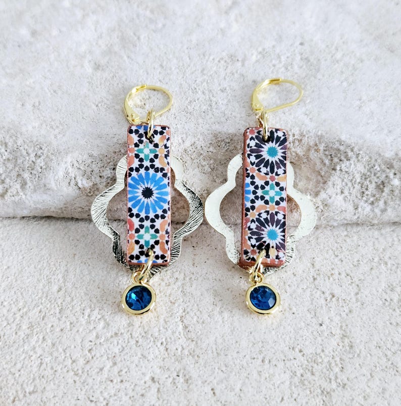 Peut inclure: Une paire de boucles d'oreilles en or avec un motif de carrelage bleu et blanc et un pendentif en pierre pr&eacute;cieuse bleue.