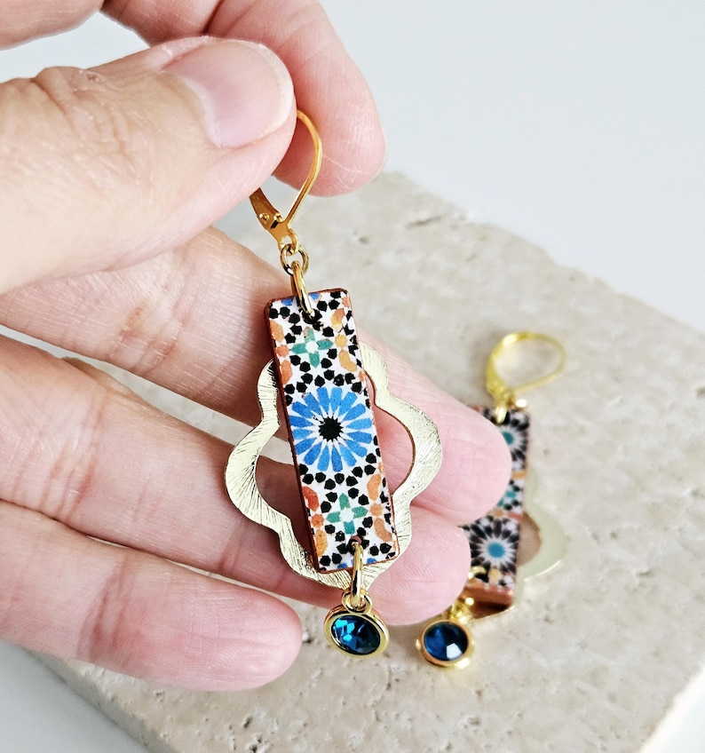 Peut inclure: Boucles d'oreilles dor&eacute;es avec un motif de carrelage bleu et orange, une forme de quadrilobe dor&eacute;e et un pendentif en cristal bleu.