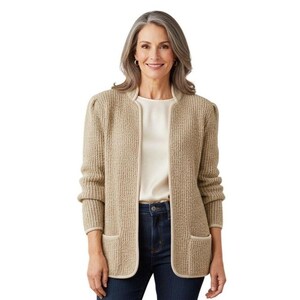 May include: A beige open-front knit cardigan featuring a textured waffle-like pattern, long sleeves with slight shoulder gathering, and two front patch pockets. The garment is worn over a plain cream-colored top and dark blue denim jeans.
