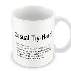 May include: White ceramic coffee mug with a black graphic that reads "Casual Try-Hard" and defines the term as a gamer who wants to appear unconcerned with the outcome of the game, but is actually trying very hard to win, and will be emotionally devastated by failure.