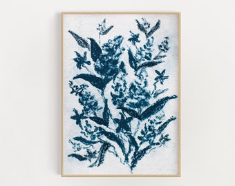 May include: A framed wall art print featuring a dark blue botanical illustration of flowers and leaves on a textured white background. The artwork displays a loose, expressive style with deep indigo pigment strokes forming a floral arrangement.