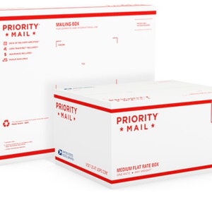 May include: Two white Priority Mail boxes. The larger box is a medium flat rate box with the text "TRACKED INSURED" in a blue shield. The smaller box is a mailing box.