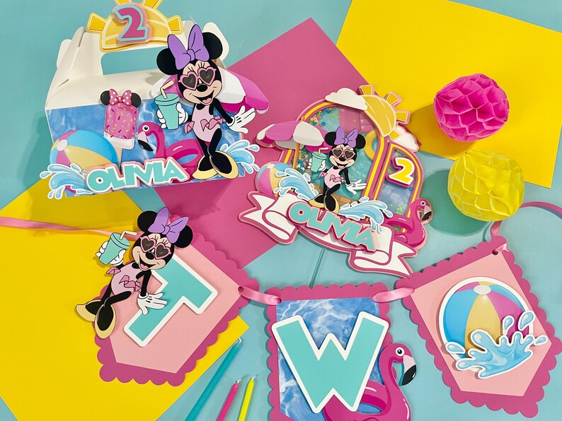 May include: A set of party decorations featuring Minnie Mouse in a swimsuit and heart-shaped sunglasses, including a box, a cake topper, and a banner spelling TWO. The items are decorated with flamingos, beach balls, and the name OLIVIA.