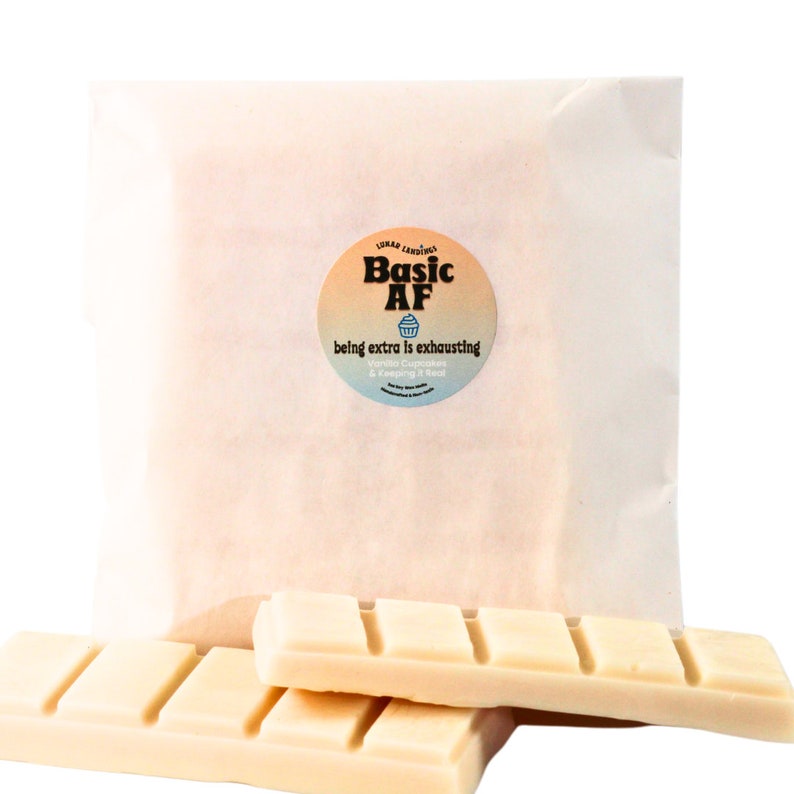 May include: Two white wax melts in a white paper bag with a sticker that says "Basic AF" with a cupcake graphic and the text "being extra is exhausting - Vanilla Cupcakes & Keeping it Real".