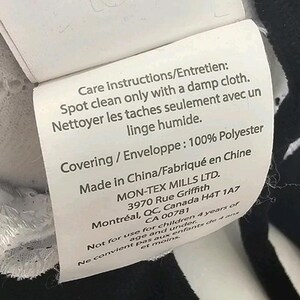 Peut inclure: Une &eacute;tiquette blanche avec du texte noir indiquant les instructions d'entretien, la composition du mat&eacute;riau et les informations du fabricant. L'&eacute;tiquette indique "Nettoyer les taches seulement avec un linge humide" et "100% Polyester".
