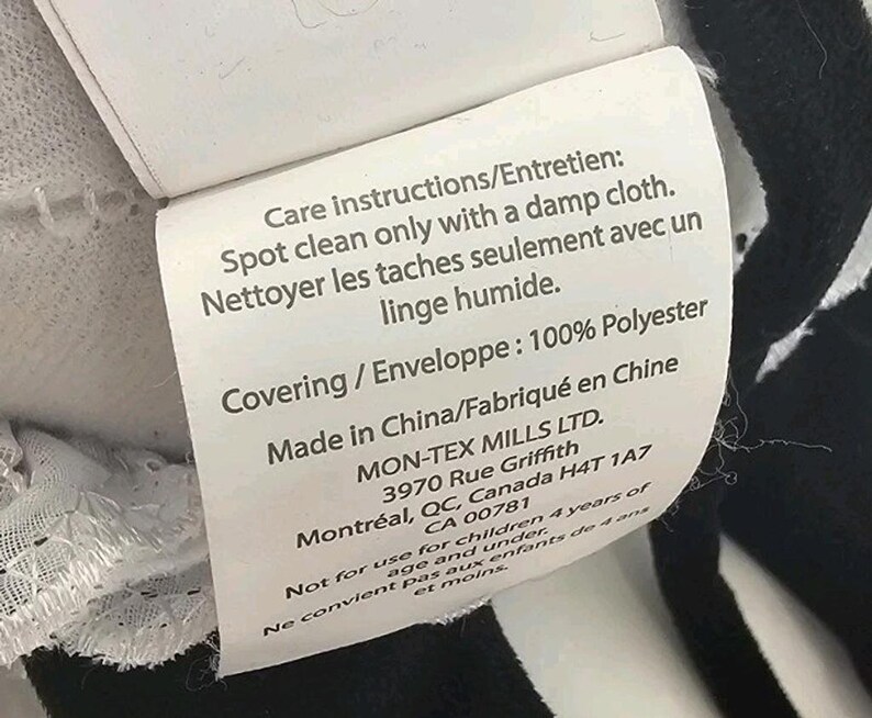 Pode incluir: Uma etiqueta de cuidados em tecido branco com texto preto. A etiqueta diz: Care instructions/Entretien: Spot clean only with a damp cloth. Nettoyer les taches seulement avec un linge humide. Covering/Enveloppe: 100% Polyester. Made in China.