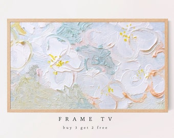May include: Abstract painting in shades of white, light blue, and peach with yellow accents. The painting is framed in a light wood frame. The text "FRAME TV" and "buy 3 get 2 free" is printed below the frame.