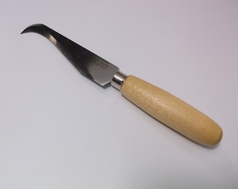 May include: A small, curved, stainless steel knife with a wooden handle. The blade is labeled "Murphy Made in USA".