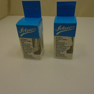Op de afbeelding: Twee dozen met Ateco 6-delige spuitmondsets, gemaakt van roestvrij staal. De dozen zijn blauw en wit met het Ateco-logo en productinformatie in het Engels, Frans en Spaans.
