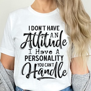 Puede incluir: Camiseta blanca con el texto negro: "I DON'T HAVE AN Attitude I Have A PERSONALITY YOU CAN'T Handle". El dise&ntilde;o es un archivo PNG para impresi&oacute;n o sublimaci&oacute;n. El texto est&aacute; en una fuente de escritura.