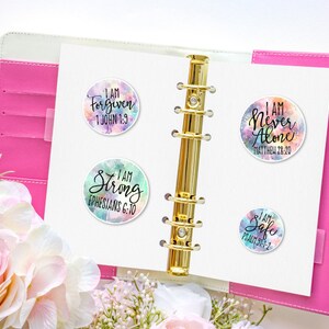 May include: Four colorful round stickers with inspirational quotes and bible verses. The stickers feature a watercolor background with a white border. The quotes are "I am Forgiven 1 John 1:9", "I am Never Alone Matthew 28:20", "I am Strong Ephesians 6:10", and "I am Safe Psalm 91:2".
