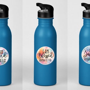 May include: Three blue water bottles with colorful, round stickers. Each sticker has a different inspirational quote and bible verse. The quotes are "I am Heard", "I am Blessed", and "I am Saved".
