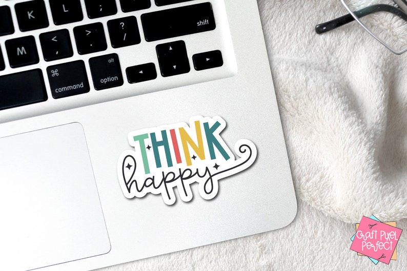 May include: A colorful sticker with the text "THINK happy" in a rainbow color scheme with a swirl at the end of the word "happy".