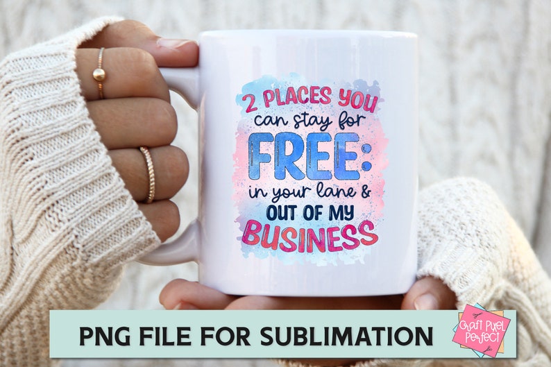 May include: White ceramic mug with a colourful watercolour design and the text "2 PLACES YOU can stay for FREE: in your lane & OUT OF MY BUSINESS".