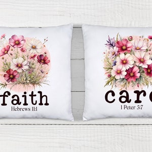 May include: Two white pillow covers with floral designs and inspirational words. The left pillow features a pink and white floral design with the word "faith" and the scripture "Hebrews 11:1". The right pillow features a pink and white floral design with the word "care" and the scripture "1 Peter 5:7".