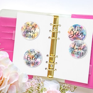 May include: Four colorful round stickers with inspirational messages and bible verses. The stickers feature watercolor-like backgrounds with a white outline. The text on the stickers reads: "I am Set Apart Psalm 4:3", "I am Set Free John 8:36", "I am Seen Genesis 16:13", and "I am Loved Romans 5:8".