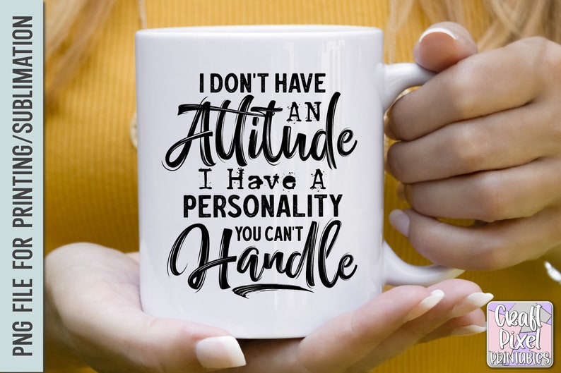 Puede incluir: Taza de cer&aacute;mica blanca con un dise&ntilde;o de texto negro. La taza presenta la frase "I DON'T HAVE AN Attitude I Have A PERSONALITY YOU CAN'T Handle" en una fuente audaz y estilizada. La taza est&aacute; sostenida por una persona.