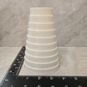 May include: White plastic stackable rings with numbers from 5 to 9 1/2, used for measuring pipe sizes.