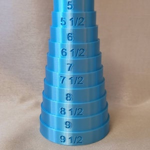 May include: A set of blue plastic ring sizers, stacked in a pyramid shape, with sizes 5, 5 1/2, 6, 6 1/2, 7, 7 1/2, 8, 8 1/2, 9, and 9 1/2.