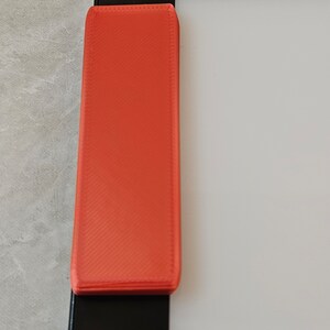 Puede incluir: Una regla de plástico naranja brillante con los números 38 a 42 impresos en ella.