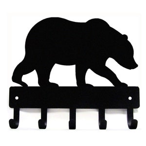 May include: Black metal key holder with a silhouette of a bear walking across the top. The key holder has five hooks.