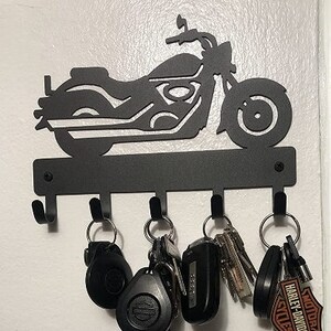 Black powder coated, five hook, metal key rack with the silhouette of a cruiser style motorcycle, the hooks hold multiple sets of keys.