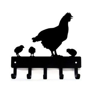 May include: Black metal key holder with a silhouette of a hen and chicks. The key holder has five hooks.