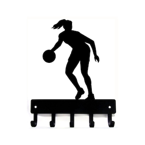 May include: Black metal key holder with a silhouette of a basketball player dribbling a ball. The key holder has five hooks.