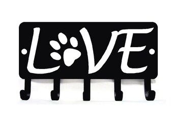 May include: Black metal key holder with five hooks and the word "LOVE" in white lettering with a paw print in the center.