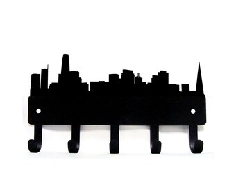 May include: Black metal key rack shaped like the San Francisco skyline with five hooks.