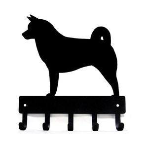 Könnte beinhalten: Schwarzer Schlüsselhalter aus Metall mit einer Silhouette eines Finnischen Lapphunds. Der Halter hat fünf Haken zum Aufhängen von Schlüsseln.