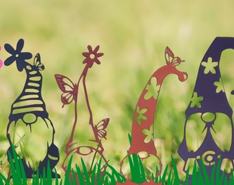 May include: Four metal garden stakes with a silhouette design of gnomes, flowers, and butterflies. The gnomes are wearing hats and have beards. The flowers are in bloom and the butterflies are in flight. The stakes are painted in shades of red, purple, and black.