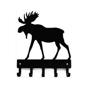 May include: Black metal moose silhouette key holder with five hooks. The moose is walking to the right. The key holder is mounted on a wall.