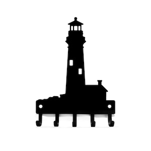 May include: Black metal lighthouse key holder with five hooks. The lighthouse is silhouetted against a white background.