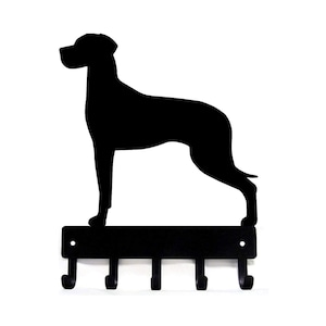 May include: Black metal key holder with a silhouette of a Great Dane dog. The key holder has five hooks.